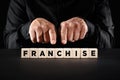 Male hands pointing to the word franchise on wooden blocks. Business model Royalty Free Stock Photo