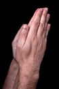 Male hands praying with palms together. Black background. Royalty Free Stock Photo