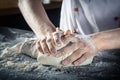 Male hands preparing pizza dough. chef in kitchen prepares the dough for gluten free pasta or bakery. baker kneads dough on the Royalty Free Stock Photo