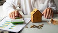 Male hands protecting the piggy bank house on the table. Real estate insurance concept Royalty Free Stock Photo