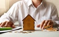 Male hands protecting the piggy bank house on the table. Real estate insurance concept Royalty Free Stock Photo