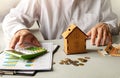 Male hands protecting the piggy bank house on the table. Real estate insurance concept Royalty Free Stock Photo