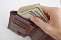 Male hands pulling a pile of American bank notes USD currency, US Dollars from a leather wallet as a symbol of successful person Royalty Free Stock Photo