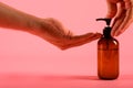 Man hands pushing pump plastic bottle isolated on pink background, clipping path. Mock up Royalty Free Stock Photo