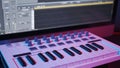 Male hands recording midi keyboard in sequencer in home studio, neon lights Royalty Free Stock Photo