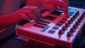 Male hands recording music using midi keyboard in home studio, neon lights Royalty Free Stock Photo