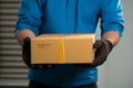 Male hands in rubber gloves hold cardboard boxes for swift online shopping delivery