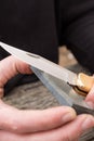 Male hands sharpening pin knife.