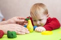 Male hands show the child plasticine pear