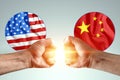 Male hands show their fists against the background of the flags of America and China. The concept of power struggle, conflict of