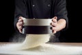 Male hands sifting flour from old sieve on old wooden kitchen table. on black background. Royalty Free Stock Photo