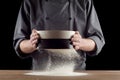 Male hands sifting flour from old sieve on old wooden kitchen table. Isolated on black background. Royalty Free Stock Photo