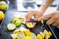 Male hands slicing lemons and limes on a black tray Royalty Free Stock Photo