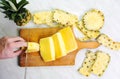 Male hands slicing pineapple fruit on a board Royalty Free Stock Photo