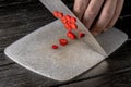 Male hands slicing rings of red hot chili pepper with a sharp knife. Chef cutting spicy cayenne peppers into thin slices Royalty Free Stock Photo