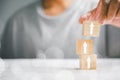 male hands stacking wooden blocks as steps on a white table