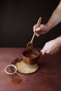 Male hands stirs melted chocolate swirl in pan on the wooden background Royalty Free Stock Photo