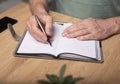 Male hands taking notes, writing plans in notebook or planner. Planning in schedule diary, close up Royalty Free Stock Photo