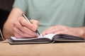 Male hands taking notes, writing plans in notebook or planner. Planning in schedule diary, close up Royalty Free Stock Photo