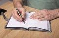 Male hands taking notes, writing plans in notebook or planner. Planning in schedule diary, close up. Starting from Royalty Free Stock Photo