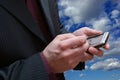 Male hands and telephone on sky background Royalty Free Stock Photo