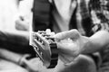 Male hands tuning guitar strings. Black and white concept. Close-up Royalty Free Stock Photo