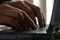 Male Hands Up Close Typing on a Laptop Computer Keyboard in an Office