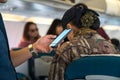 Male hands using modern smartphone in aircraft, businessman typing text message waiting for airplane to be ready after landing Royalty Free Stock Photo