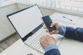 Male hands using smartphone mockup with blank screen at office desk with an open laptop mockup and tablet computer. For Royalty Free Stock Photo