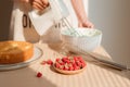Male hands whipping whites cream in glass bowl with mixer on wooden table. Making sponge cake or red velvet cake Royalty Free Stock Photo