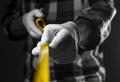 Male hands in white building gloves holding yellow retractable tape measure tool spread to camera, closeup