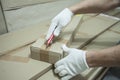 Male hands in white gloves with a knife unpack the box.