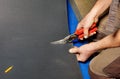 A worker cuts a sheet of roofing iron with metal scissors Royalty Free Stock Photo