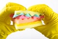 Male hands in yelliw gloves holding a burger made from sponges different colors. Concept of unhealthy food and non Royalty Free Stock Photo