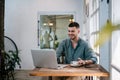 A male, Handsome Freelance man enjoying working on laptop at desk. freelance concept Royalty Free Stock Photo