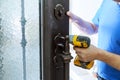 Male handyman carpenter at interior metal door lock installation