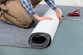 Male Handyman Rolling Carpet On Floor Royalty Free Stock Photo