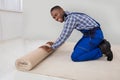 Male Handyman Rolling Carpet Royalty Free Stock Photo
