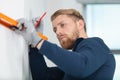 male handyman using spirit level to draw line on wall Royalty Free Stock Photo