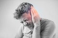 Male having ear pain touching his painful head isolated on gray Royalty Free Stock Photo