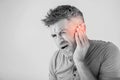 Male having ear pain touching his painful head isolated on gray Royalty Free Stock Photo