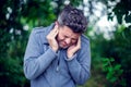 Male having ear pain touching his painful head outdoor Royalty Free Stock Photo