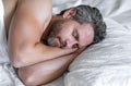 Male head on pillow. Gray hair man sleep in white bed. Senior man sleep in bed at bedroom. Mature man sleeps at home at Royalty Free Stock Photo