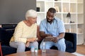 Male health worker with digital tablet discussing with caucasian senior woman over medication dose