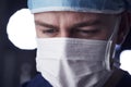 Male healthcare worker in scrubs, head shot, looking down