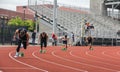 Male high school runners come off the blocks