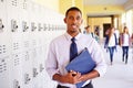 Male High School Teacher Standing By Lockers