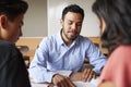 Male High School Tutor With Two Students At Desk In Seminar Royalty Free Stock Photo