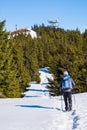 Hiker walking through deep snow to summit of mountain Rennfeld