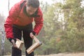 Male hiker cutting firewood in forest Royalty Free Stock Photo